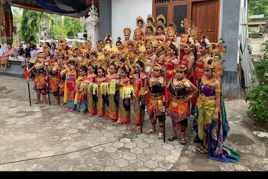 Bailarinas balinesas con tocados dorados, esperando el inicio de una ceremonia