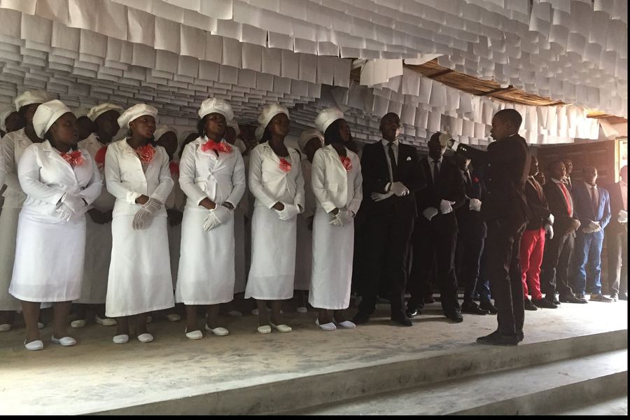 Un coro vestido de blanco canta en una iglesia de Mozambique