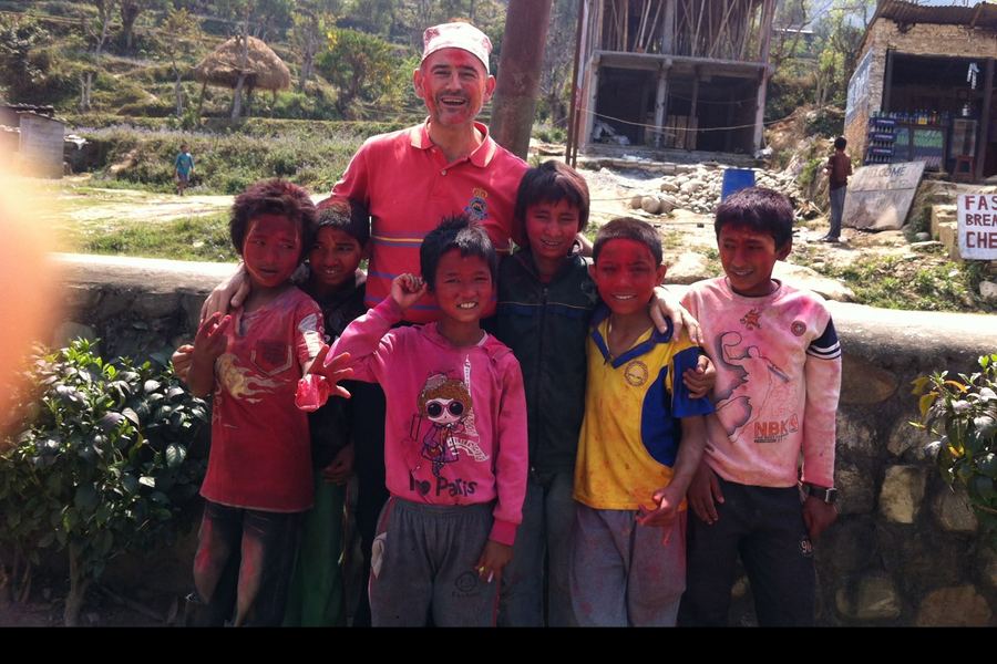 Alejandro, cubierto de polvos de colores, rodeado de ni&ntilde;os durante el festival Holi en Nepal