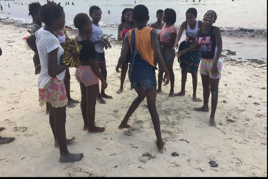 Un grupo de chicas juega y r&iacute;e en una playa de Pemba, al atardecer