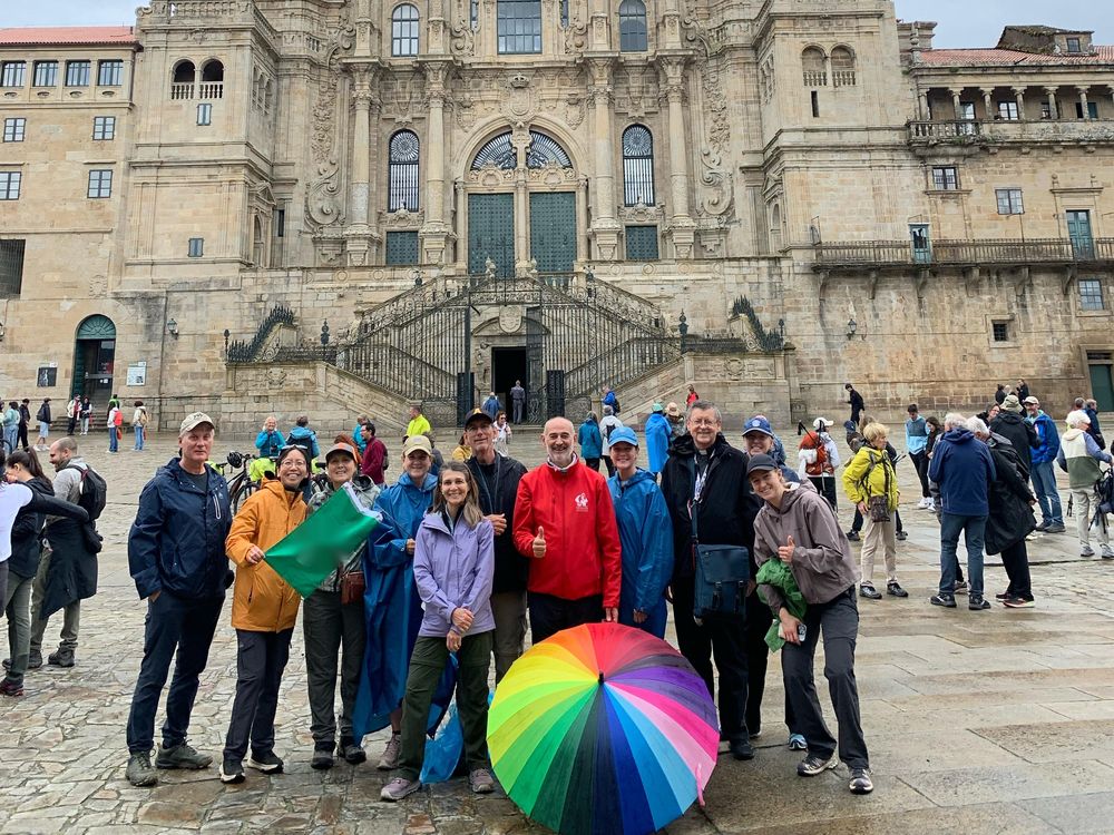 Un grupo de peregrinos posa bajo la fachada de la catedral de Santiago