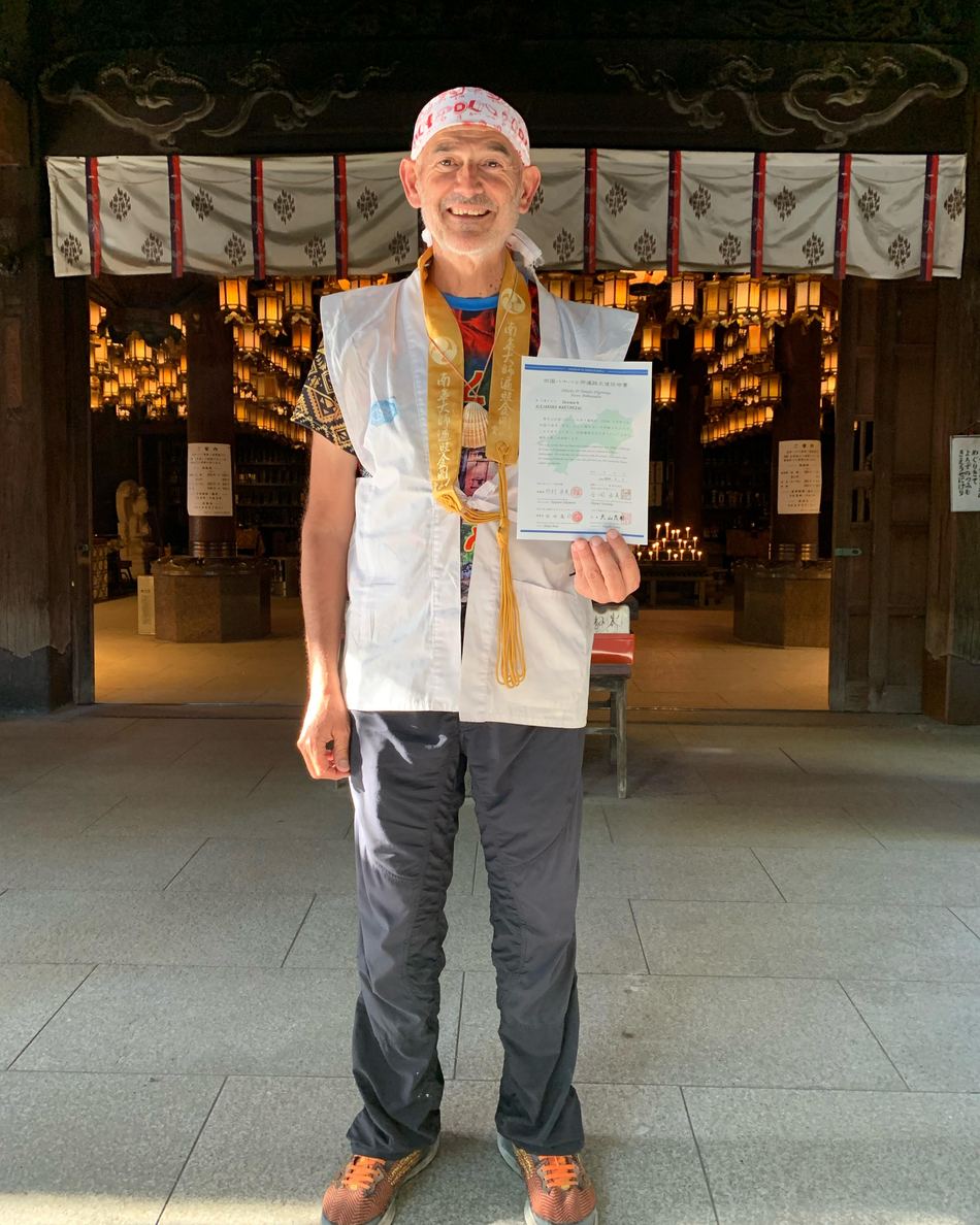 Alejandro, vestido de ohenro, muestra el certificado de los 88 templos de Shikoku