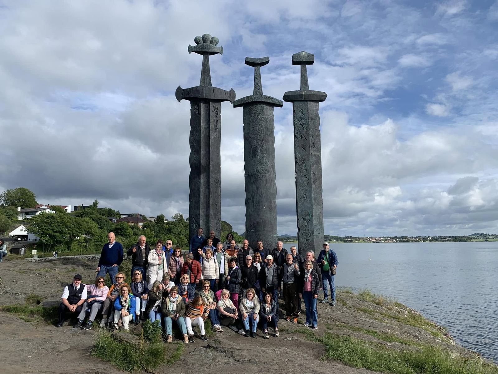 Un grupo numeroso posa ante el monumento de las espadas en la roca, en Stavanger